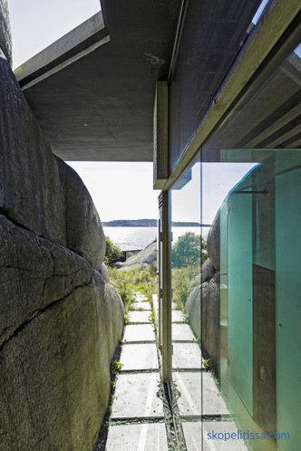 Casa con paredes transparentes en costas rocosas soleadas en Sandefjord, Noruega